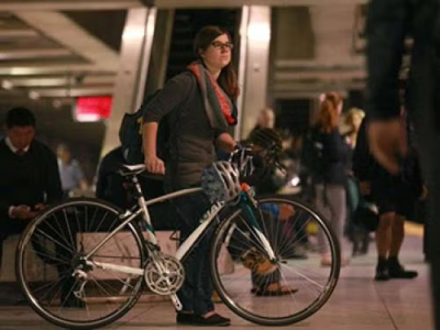 Woman walking her bike inside a station