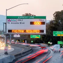 A freeway express lane sign displaying the toll to Alcosta Blvd, and indicating that Fastrak is required to pay the toll.