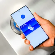 A hand holding a phone showing the Clipper card.