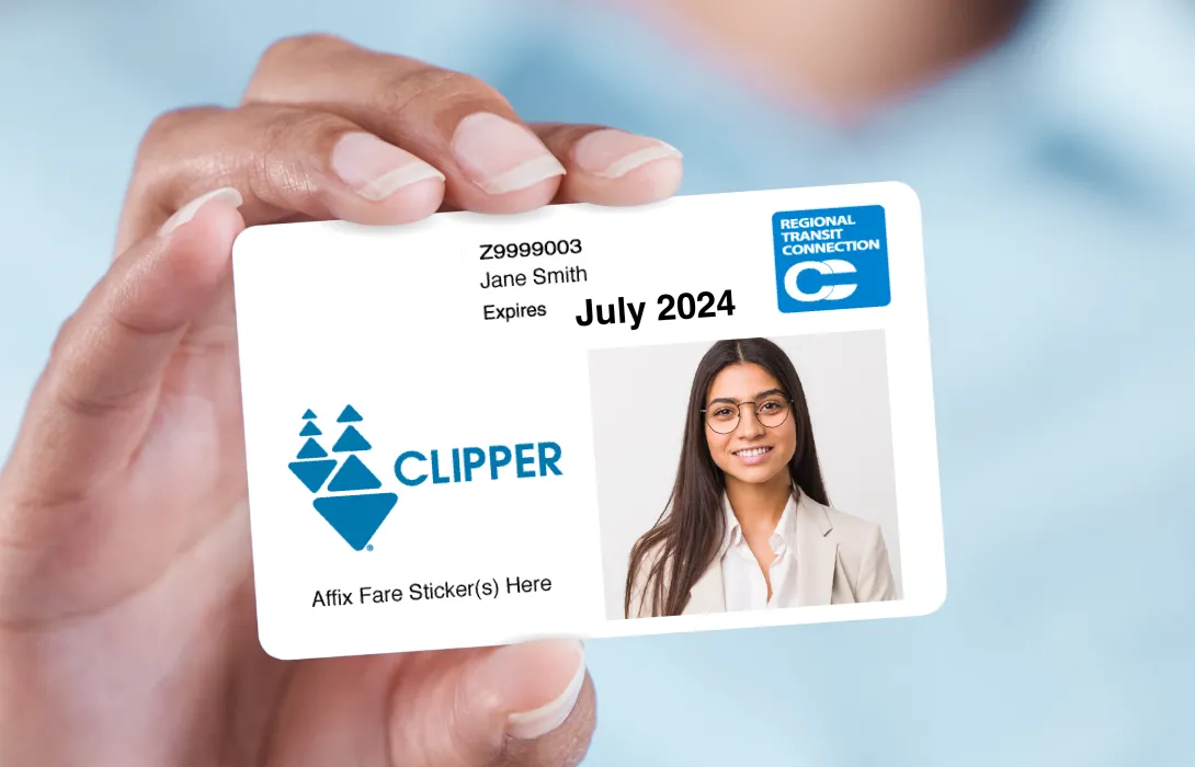Photograph of a sample clipper card issued to Jame Smith that expires on July 2024.  It features a photo of a young woman, a Regional Transit Connection logo and a Clipper logo.  There is a message on the bottom of the card that reads "Affix Fare Sticker(s) Here"