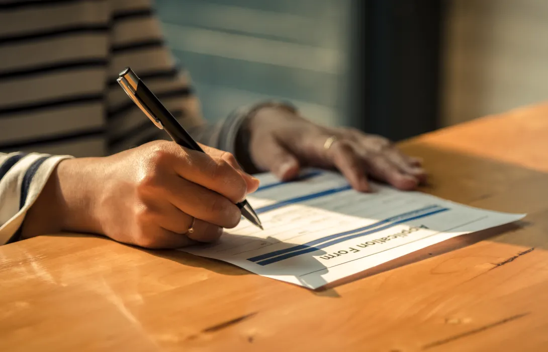 An application form being filled out in pen