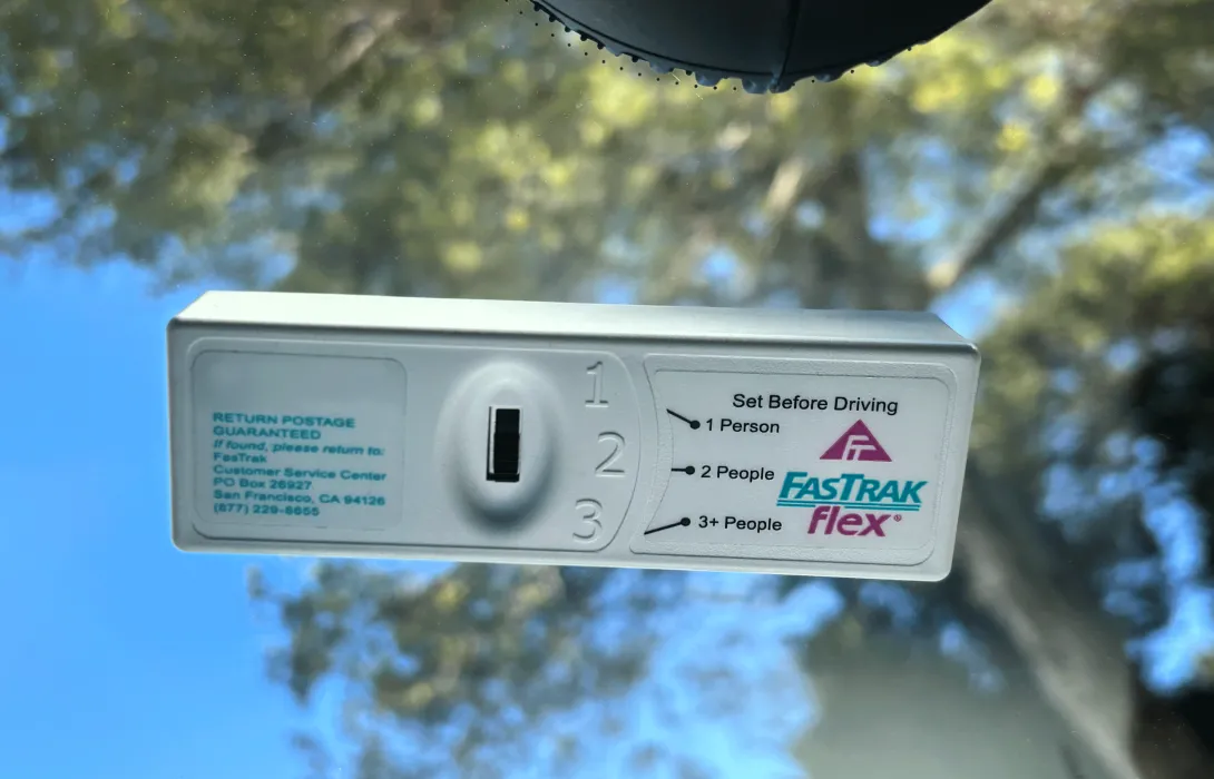 FasTrak tag inside a car windshield, showing a selector switch for the number of people in the car.