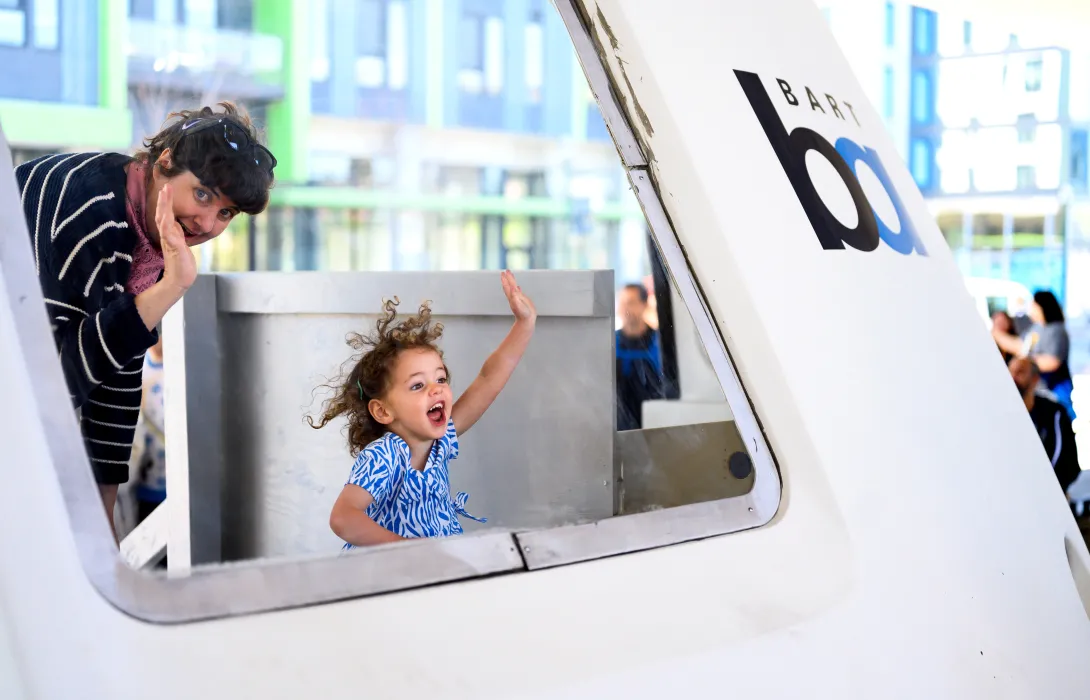 mom and child waving out of a train window