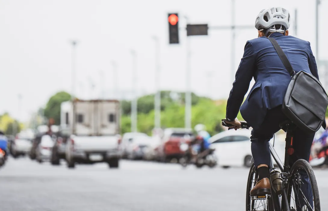 Someone in a suit riding a bicycle in traffic