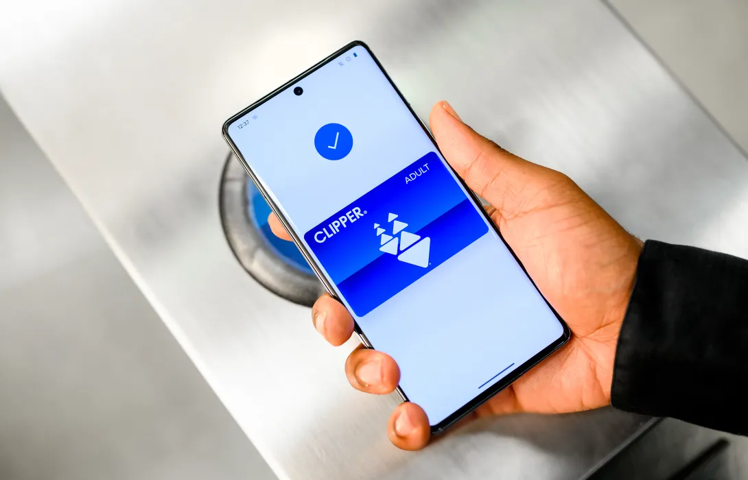 A hand holding a phone showing the Clipper card.