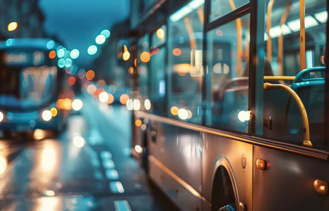 Buses driving through a city street at night